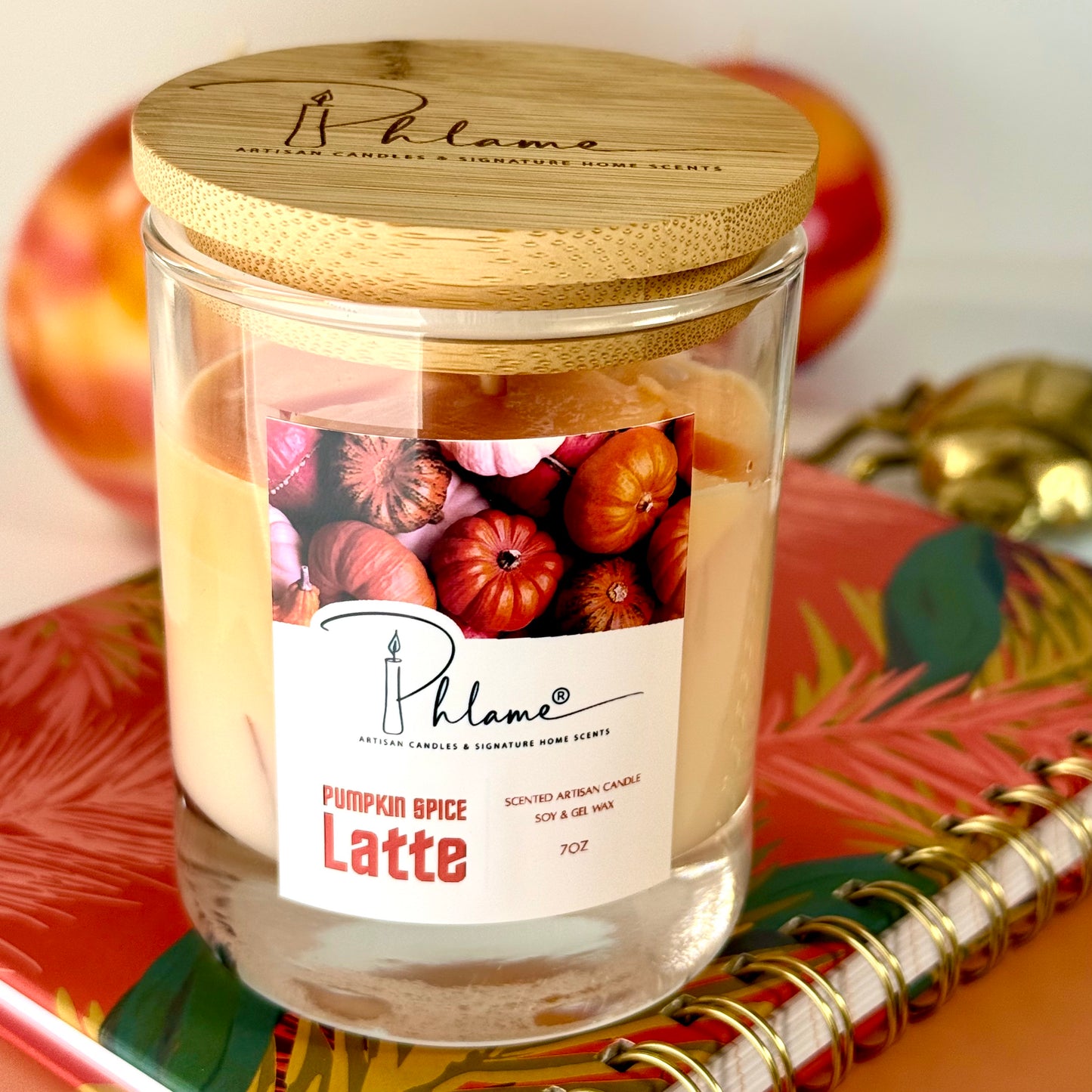 Candle jar labeled 'Pumpkin Spice Latte' with a wooden lid on a decorative surface.