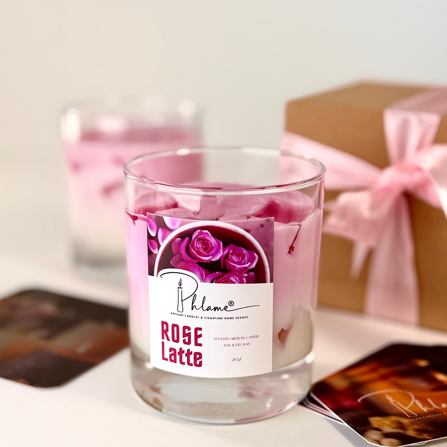 Glass candle labeled 'Rose Latte' with a decorative box in the background