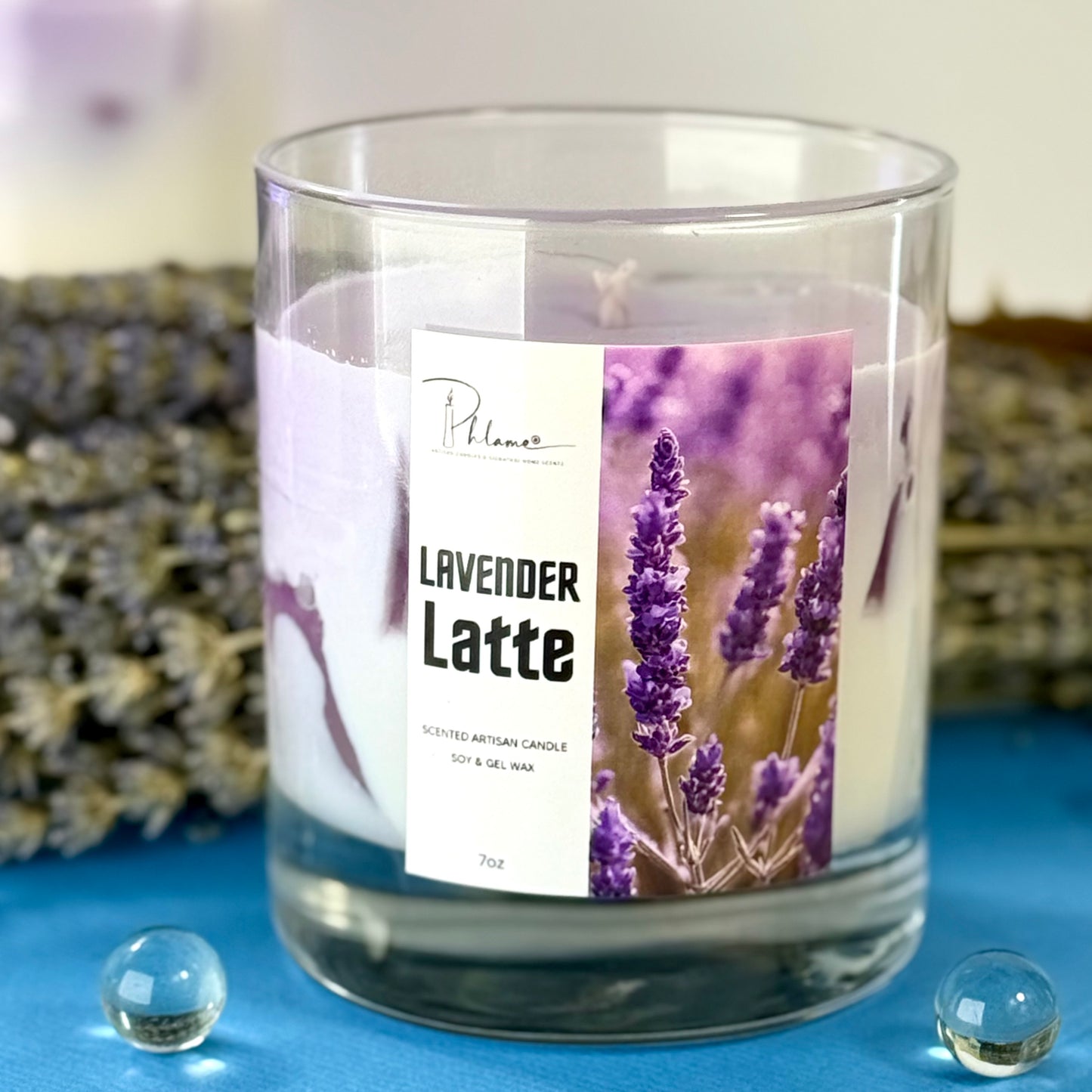 Glass candle with 'Lavender Latte' label and lavender image on a blue surface