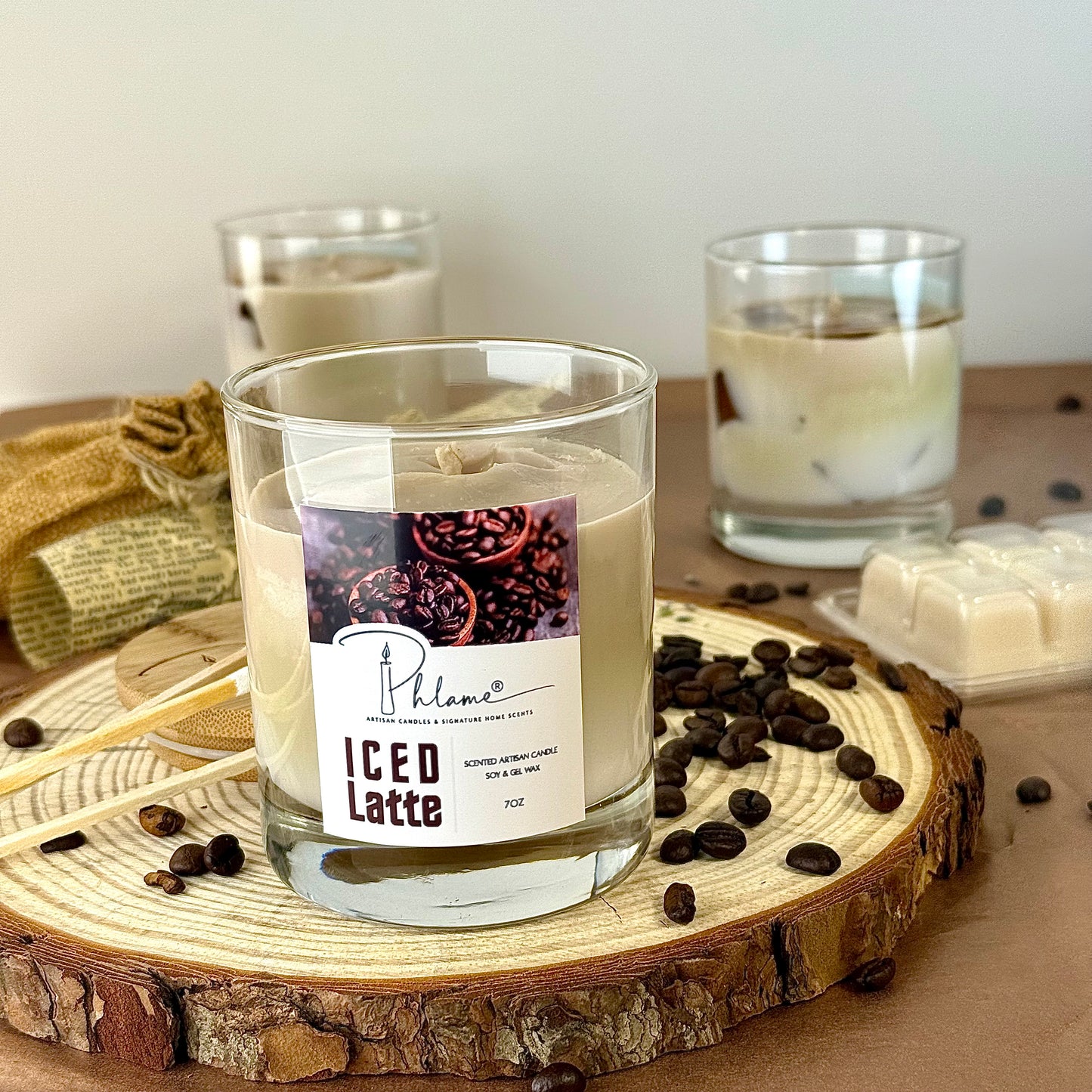 Candle labeled 'ICED LATTE' with coffee beans on a wooden coaster