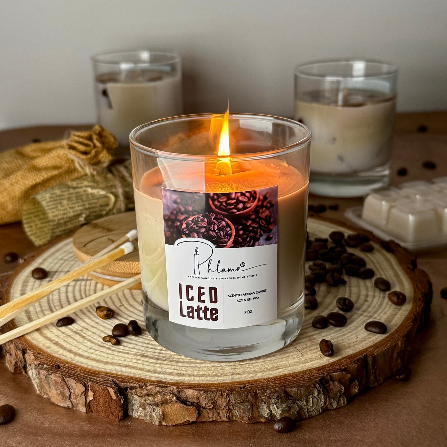 Candle labeled 'ICED Latte' with coffee beans and a glass of iced latte in the background.