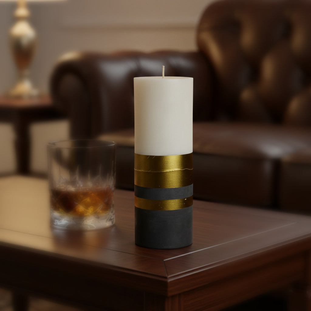 Decorative candle with gold and black design on a wooden table in a cozy living room setting.