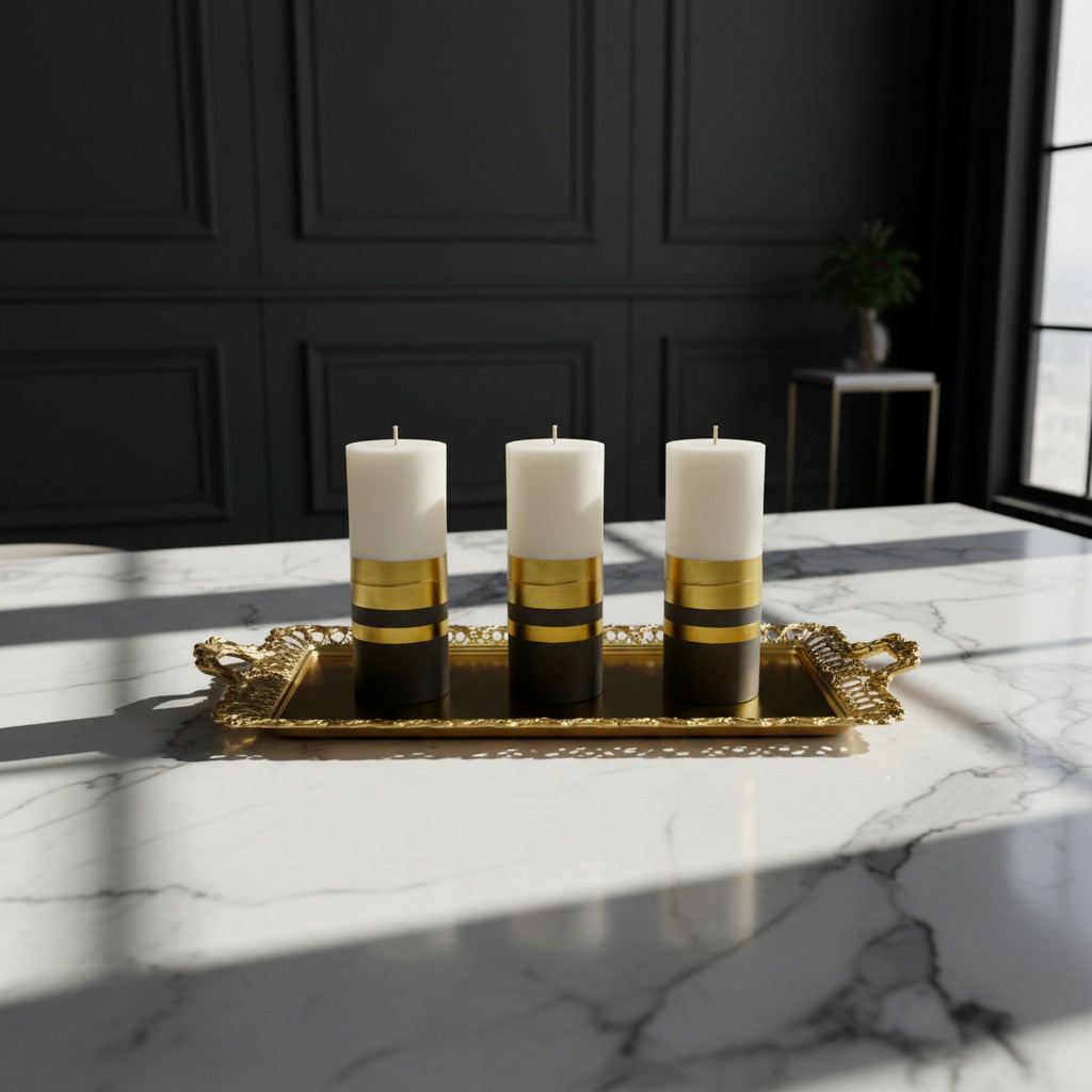 Three candles with gold and black bases on a decorative tray in a sunlit room.