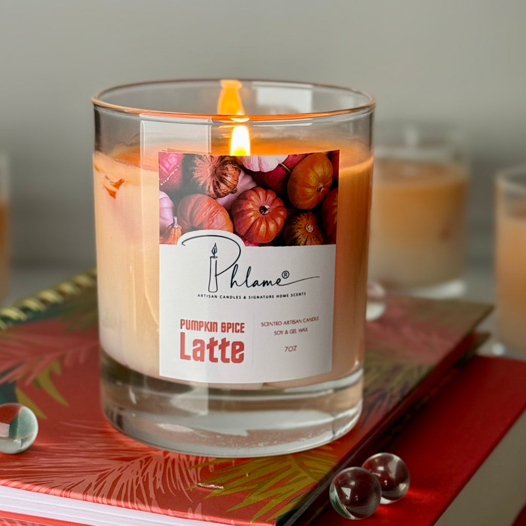 Candle labeled 'Pumpkin Spice Latte' with a Phlame brand on a decorative surface.