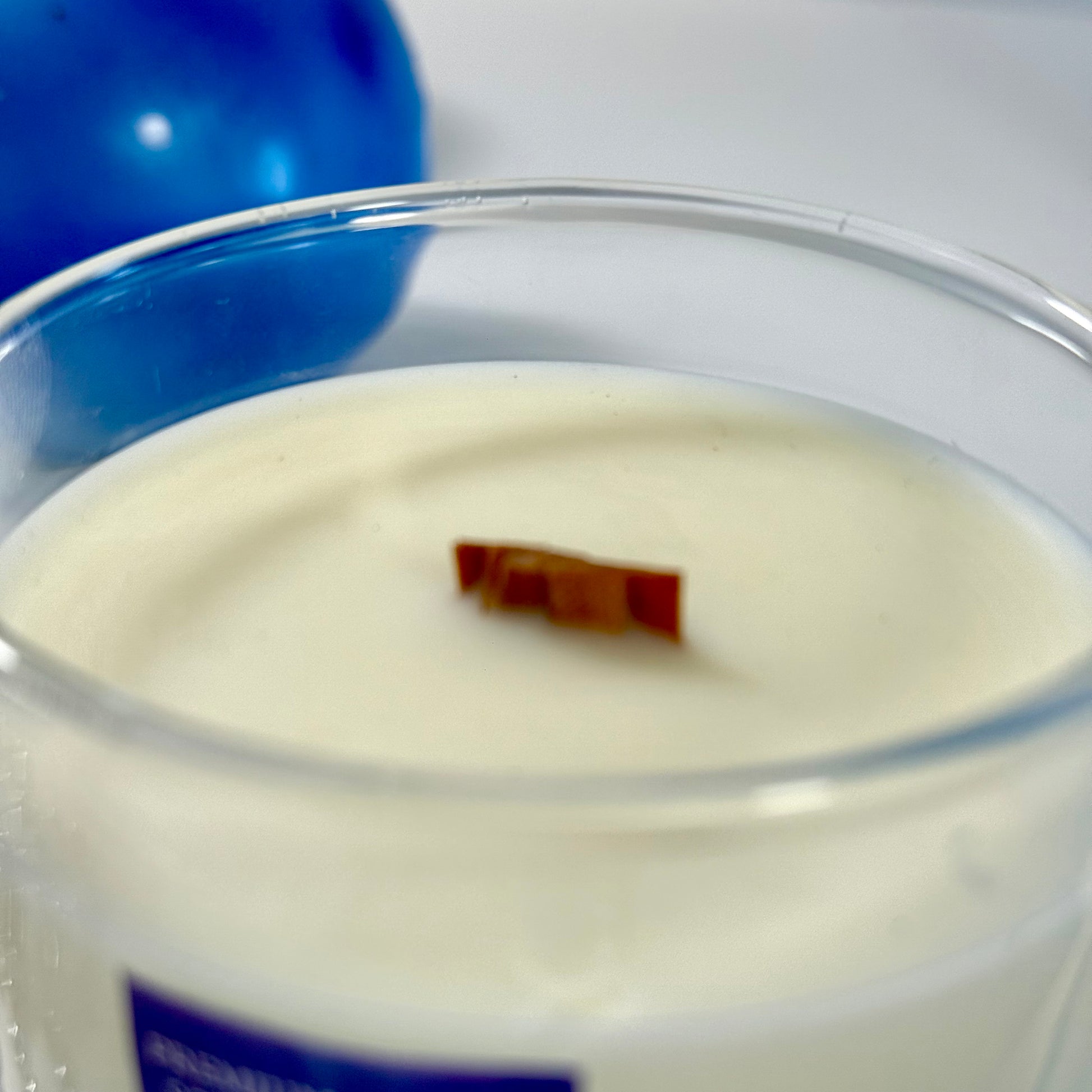 Radiant Savage candle with blue wax detail and black gift box, styled with cool-toned décor.