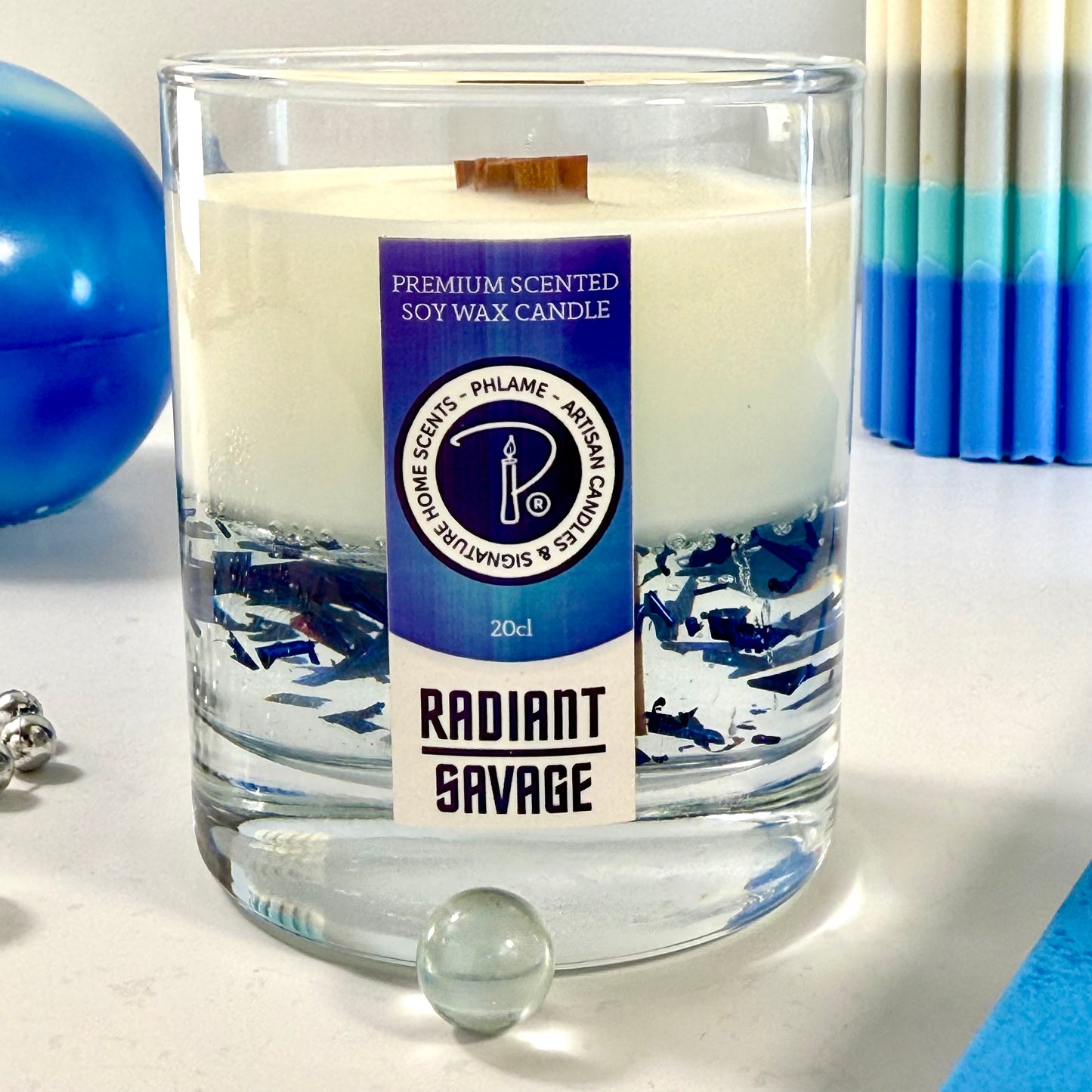 Radiant Savage candle with blue wax detail and black gift box, styled with cool-toned décor.