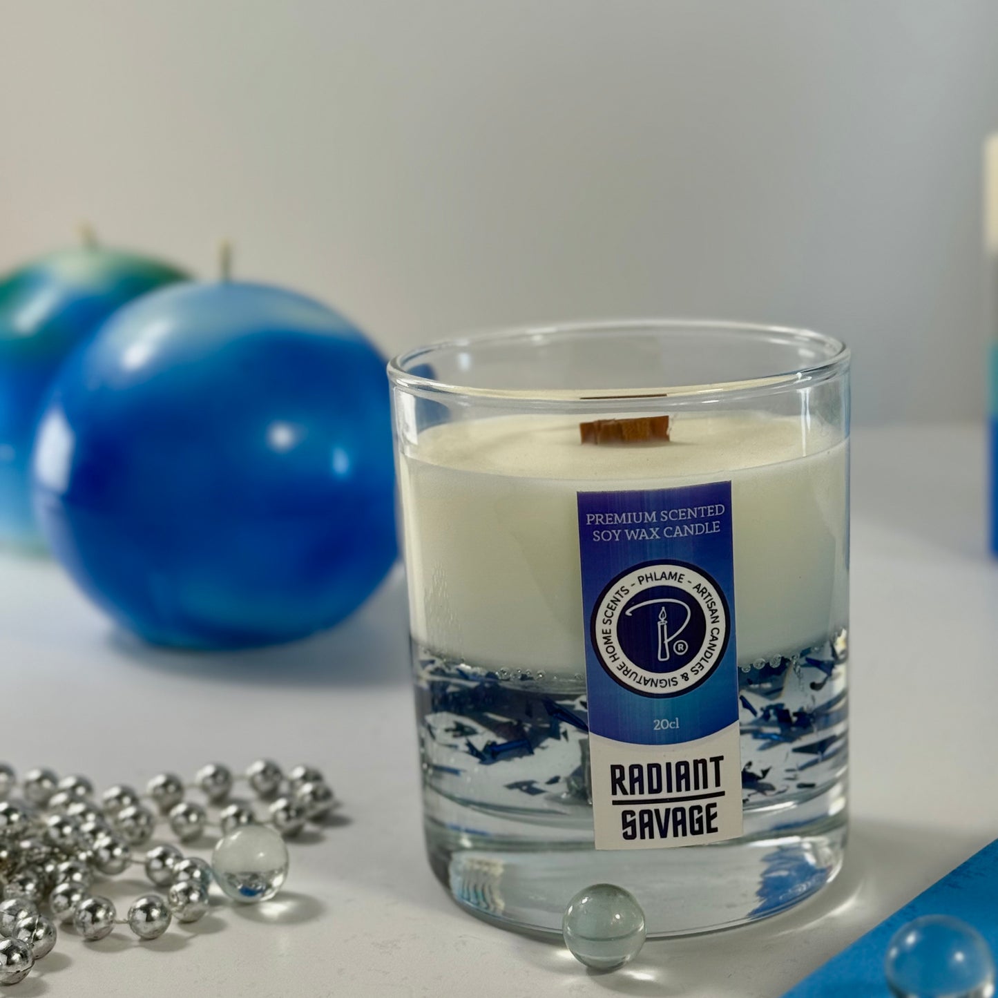 Radiant Savage candle with blue wax detail and black gift box, styled with cool-toned décor.