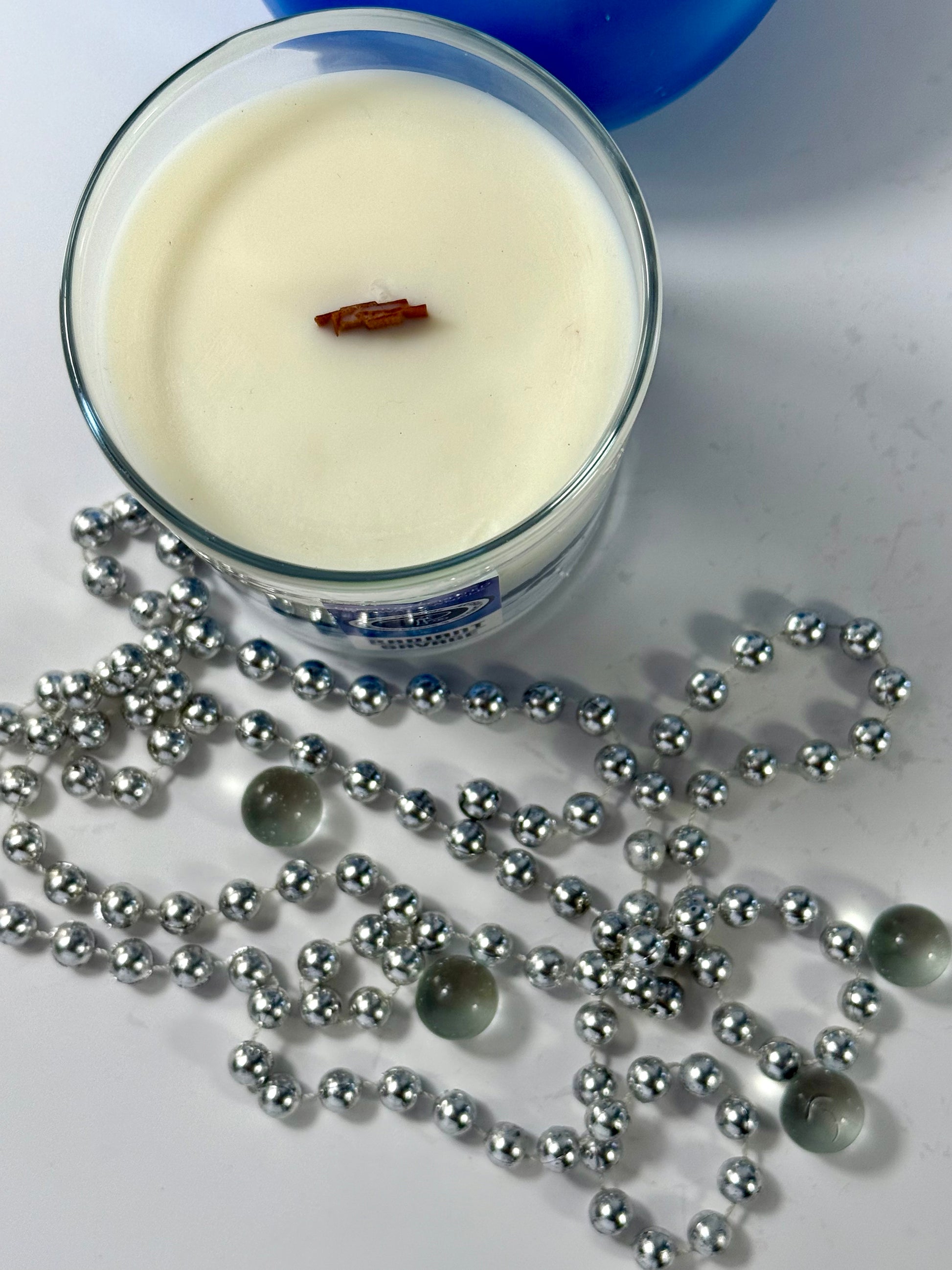 Radiant Savage candle with blue wax detail and black gift box, styled with cool-toned décor.