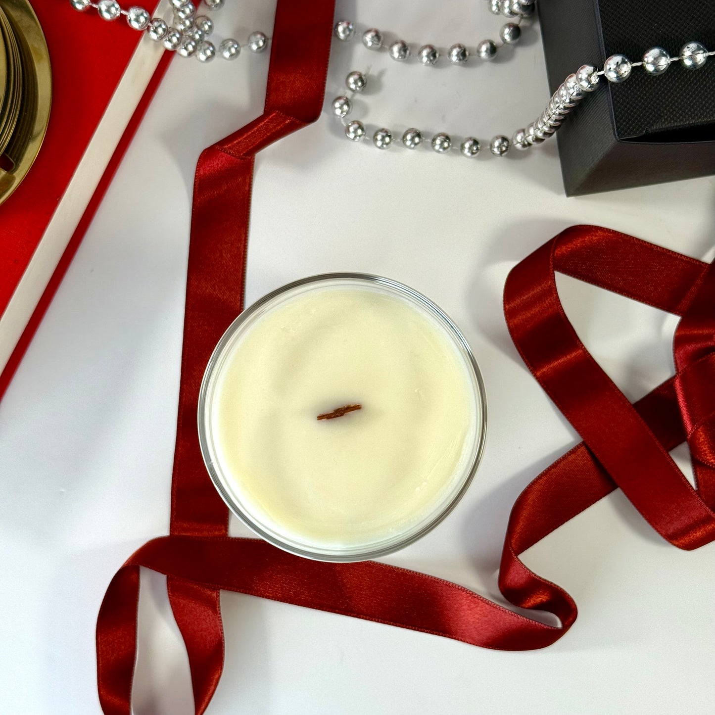 Radiant Baccarat candle with red gel wax and elegant black box, styled for luxury.