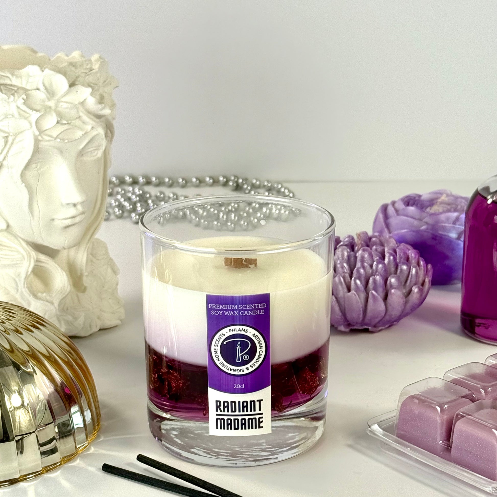 Radiant Madame candle with purple wax and black gift box, styled with feminine décor.