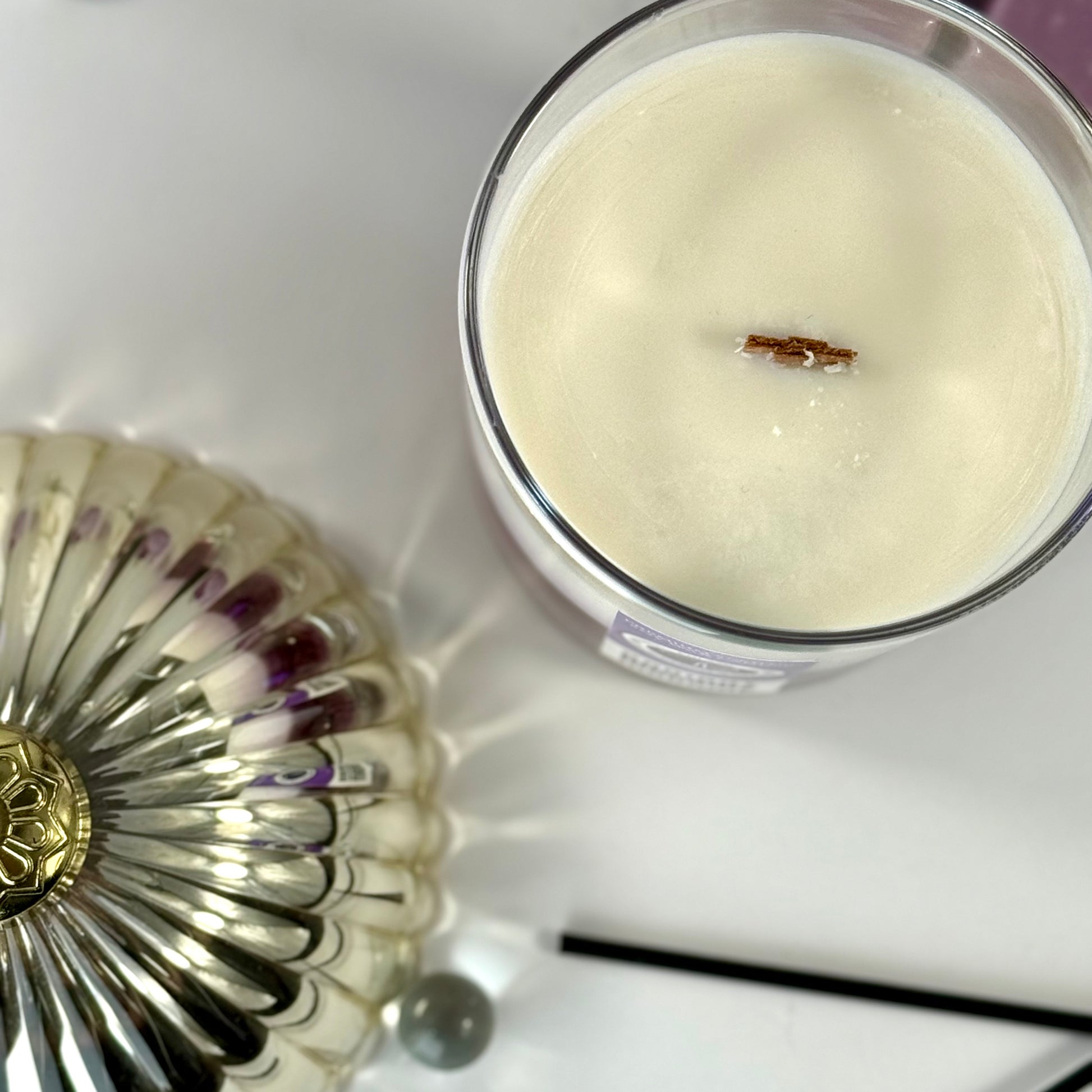 Radiant Madame candle with purple wax and black gift box, styled with feminine décor.