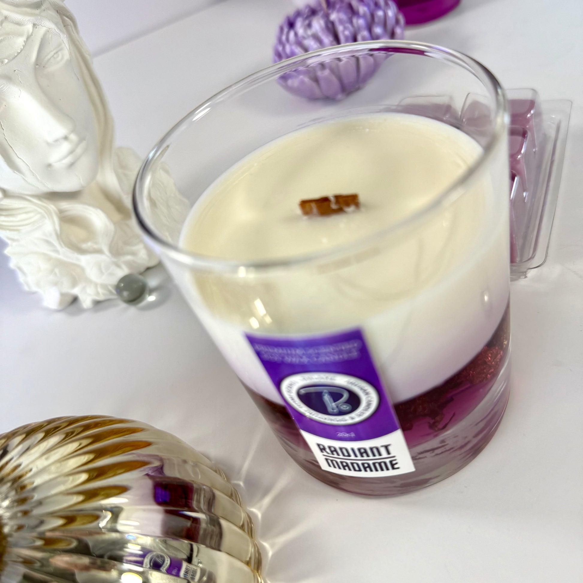 Radiant Madame candle with purple wax and black gift box, styled with feminine décor.