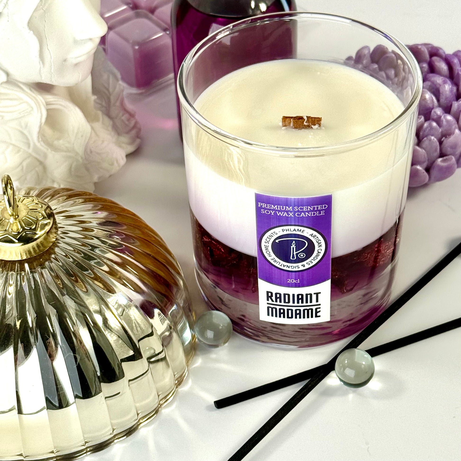 Radiant Madame candle with purple wax and black gift box, styled with feminine décor.