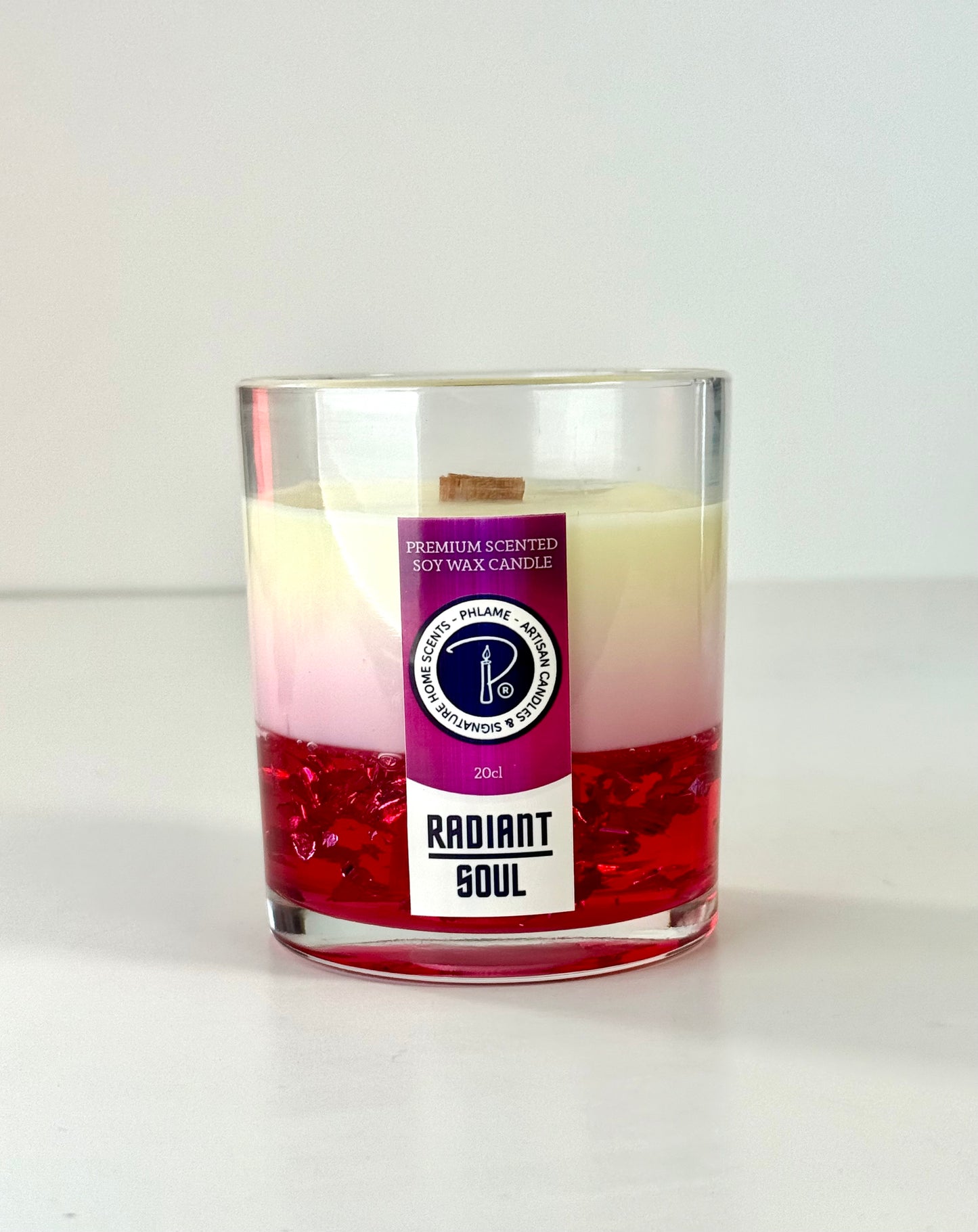 Radiant Soul candle with red gel wax and wooden wick, displayed in gift setting.
