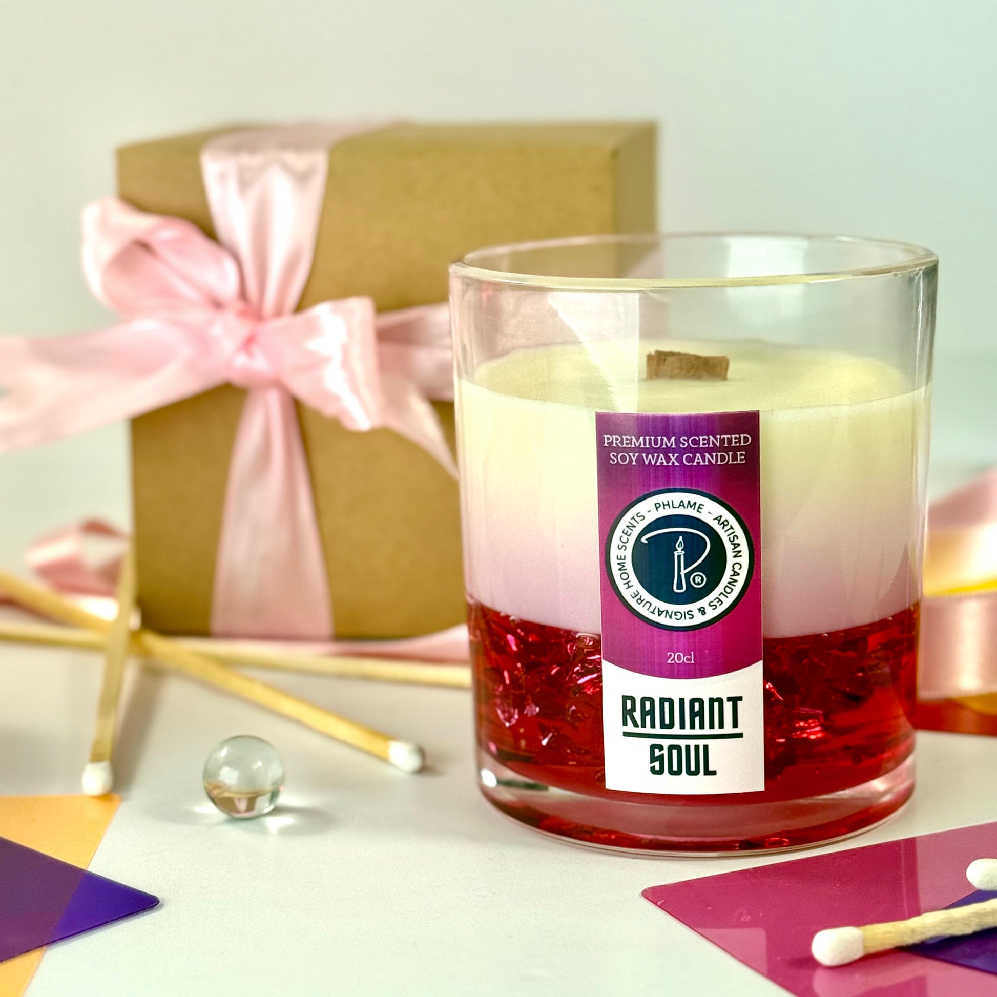 Radiant Soul candle with red gel wax and wooden wick, displayed in gift setting.