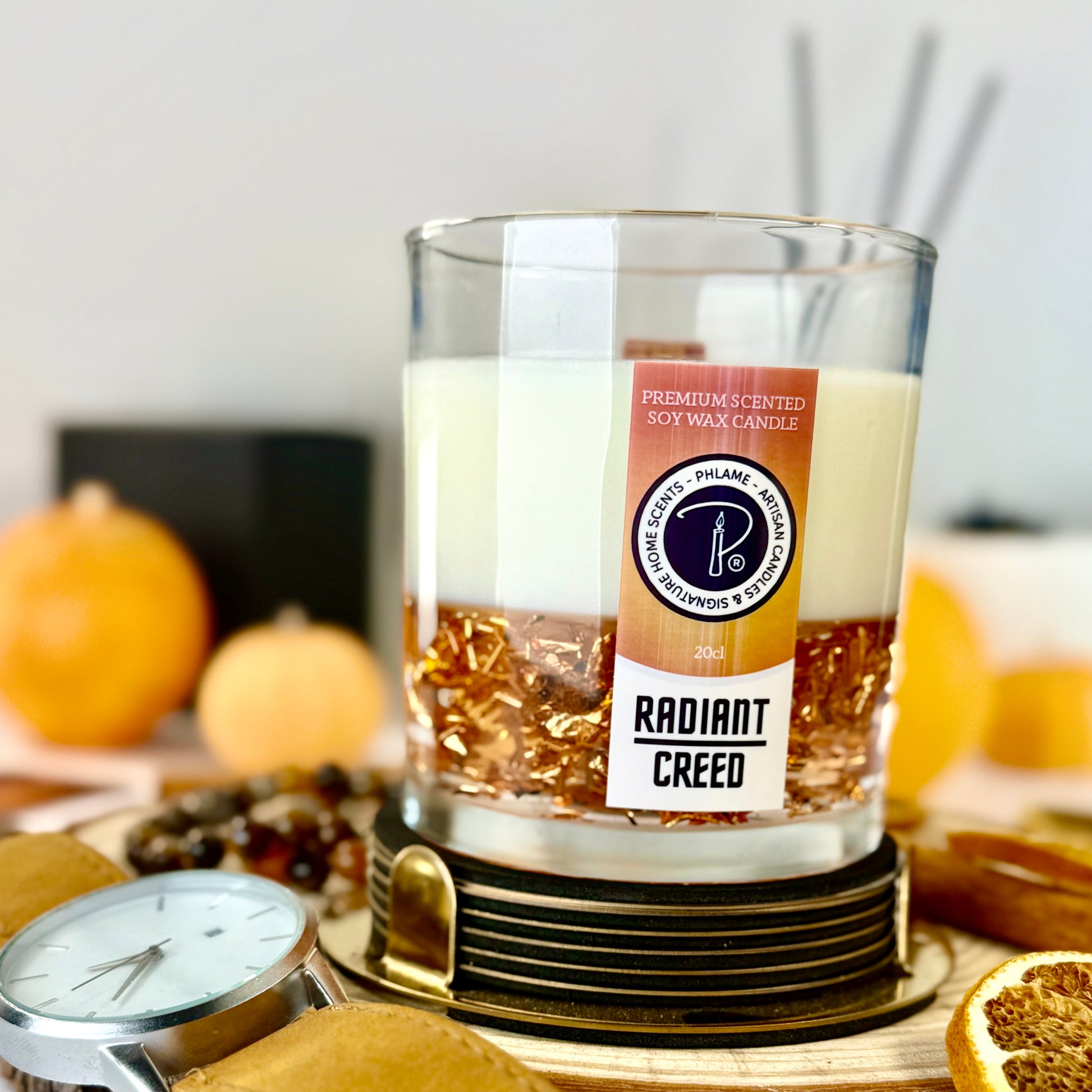 Radiant Creed candle with layered wax and wooden wick in black gift box, styled with citrus and spices.