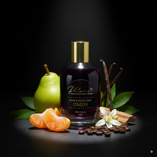 Bottle of Phlame room spray with fruits, spices, and leaves on a dark background